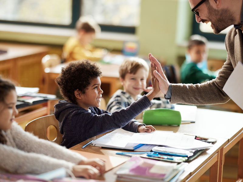 student high fiving teacher