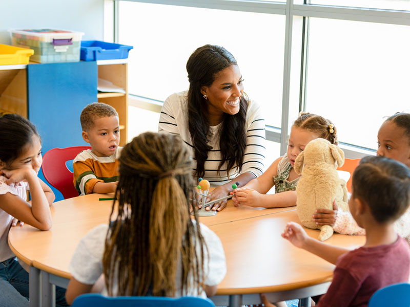 teacher teaching students at table