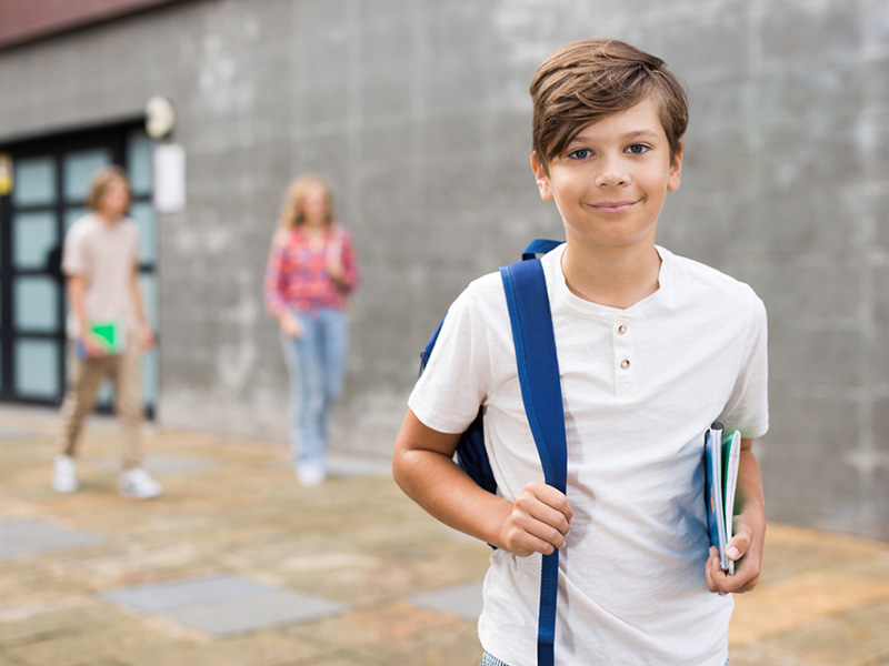 Young boy standing at school building