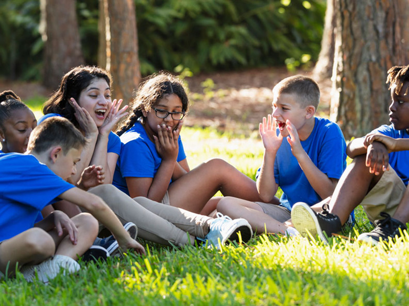 Multiracial children with counselor at summer camp