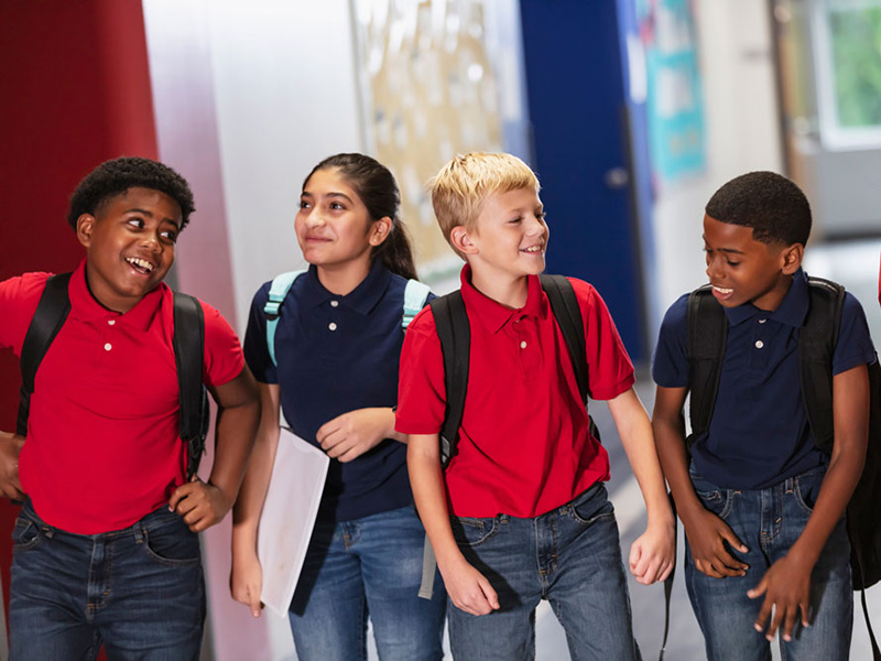 Multiracial middle school students walking in hallway